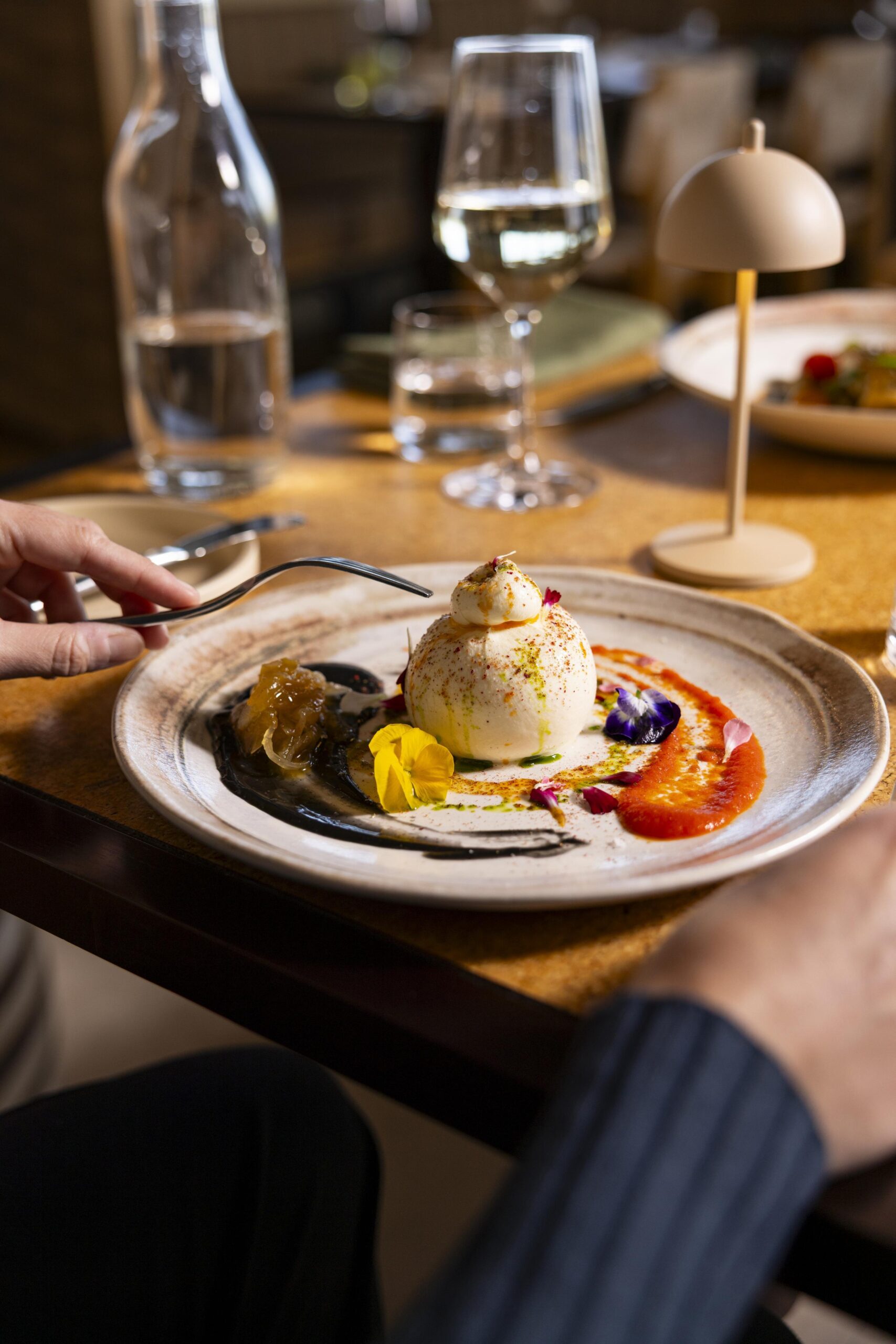 A guest dining at a table about to eat a dish