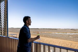 Man drinking wine on a balcony